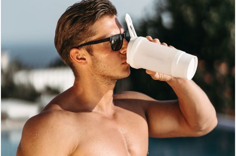 shirtless-young-man-drinking-water-against-sky-royalty-free-image-1655453438